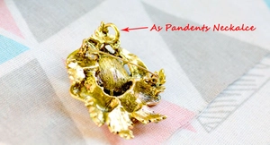 Detailed back view of gold crystal brooch showing pin and necklace pendant hook