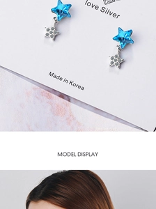 Close-up of blue star stud earrings on card and worn by model in detail view