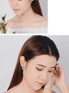 Detail of blue and white crystal star drop earrings shown worn on model for scale