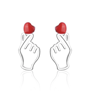 Minimalist silver heart gesture stud earrings with red epoxy finish on white background