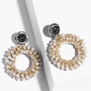 Macro shot of elegant beige beaded hoop earrings with shimmering crystal stud details