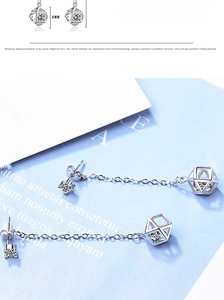 Detail of silver geometric cube drop earrings with 8mm zircon stone on a blue card