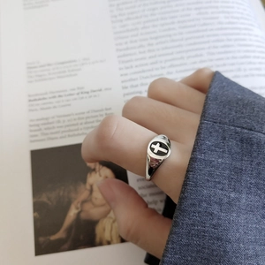 Detail of 925 sterling silver cross signet ring worn with a casual gray blazer