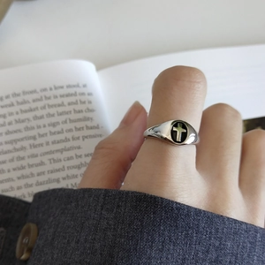 Close-up of vintage 925 silver cross ring with black drip oil finish on a finger