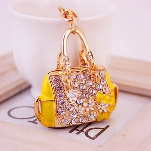 Golden handbag keychain with crystal rhinestones and yellow flower details