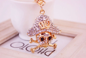 Close-up of golden pirate skull keychain encrusted with sparkling clear rhinestones