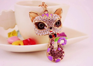 Detailed view of cat keychain with purple enamel and shimmering white rhinestones