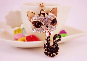 Close-up of golden cat keychain with sparkling rhinestones and black spotted pattern