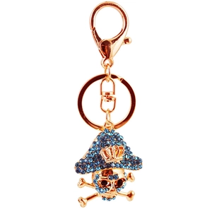 Golden pirate skull keychain with blue rhinestones and crown detail on a white background