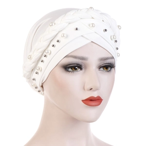 Close-up of white turban hat featuring braided band with pearls and silver beads