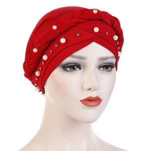 Close-up of red turban cap with braided detail, white pearls, and silver beads