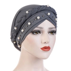 Close-up of dark grey turban featuring woven cross design and elegant white pearls