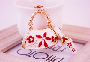 Detail of floral enamel bag keychain with rhinestones and matching high heel charm