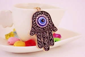Detail of Hamsa Hand keychain with black enamel, evil eye, and white rhinestones