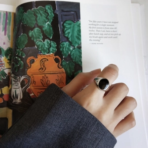 Close-up of a 925 sterling silver oval black enamel ring worn by a model in a lifestyle setting