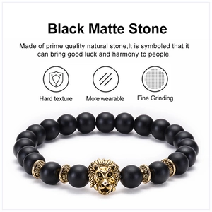 Macro detail of 8mm matte black natural stone beads and golden lion head ornament