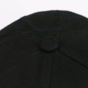 Macro shot of the black cotton baseball cap top showing detailed stitching and squatchee