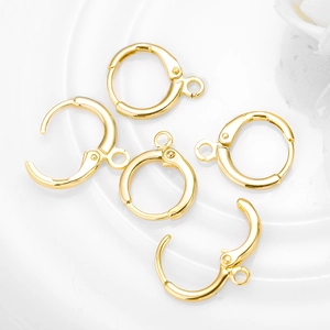 Five shiny golden metal earring hoops for DIY jewelry making on white background
