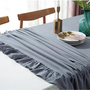 Close-up of gray ruffled edge cotton tablecloth with vintage washed texture in a home setting