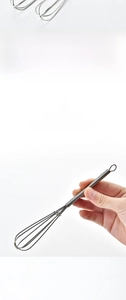Close-up of mini stainless steel whisk featuring a flexible elastic spring handle for mixing