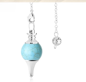 Macro detail of turquoise crystal pendulum pendant with ornate silver metal casing