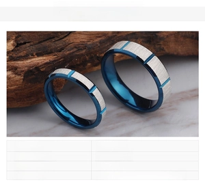 Detailed view of blue electroplated and brushed silver stainless steel couple rings