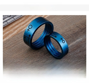 Macro shot of blue electroplated stainless steel couple rings with male and female symbols