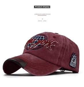 Detailed side view of washed burgundy cotton baseball cap with New York patch embroidery