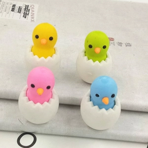 Close-up of four colorful chick-in-eggshell erasers in yellow green pink and blue colors