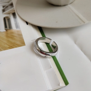 Close-up of minimalist adjustable 925 sterling silver ring on magazine background