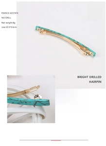 Detail of turquoise marble acetate hair clip with golden spring clasp mechanism