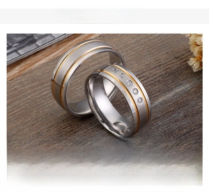 Detail of matte stainless steel couple rings with gold inlay and small diamonds