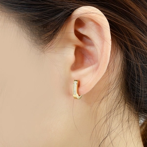 J-shaped 18K gold plated hoop earrings with shimmering zircons worn by a female model