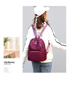 Model wearing purple quilted nylon backpack for women with adjustable shoulder straps