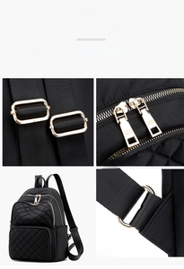 Detail view of black quilted nylon backpack with multiple zipper pockets and gold hardware