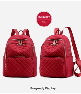 Detail of wine red nylon backpack featuring classic diamond quilting and silver zippers