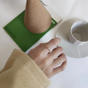 Elegant gold heart ring with red stones worn on hand in a lifestyle setting