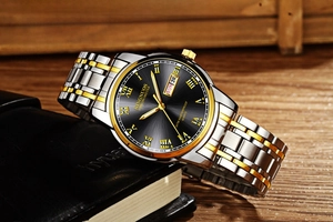 Detail of quartz watch with black dial, roman numerals, and gold-silver steel strap