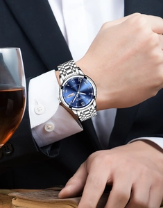 Men's business quartz watch with blue dial and steel strap worn by a person in a suit