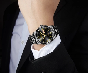 Men's black quartz watch with gold roman numerals on a wrist in professional business attire