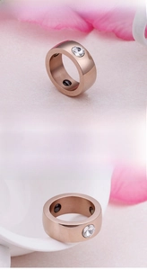 Detail view of rose gold stainless steel ring featuring clear zircon and black magnets