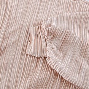 Detailed macro shot of pink pleated satin fabric showing glossy texture and cuff design
