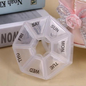 Close-up of a 7-day pill organizer with rotating lids and daily weekday labels