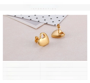 Close-up of golden heart earrings in 18K gold plating with polished metal texture