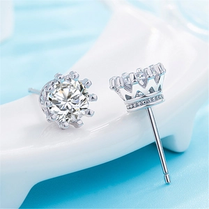 Macro shot of silver crown stud earrings with round clear diamonds and multi-prong setting