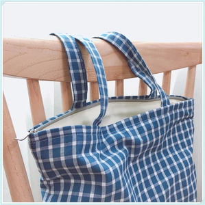 Détail du sac en coton à carreaux bleus et blancs avec fermeture éclair et doublure douce