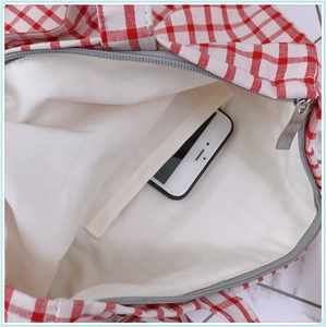 Vue intérieure d'un sac cabas en toile à carreaux rouges montrant la poche interne