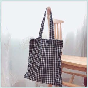Détail de la texture d'un grand sac fourre-tout à carreaux noir et blanc en toile