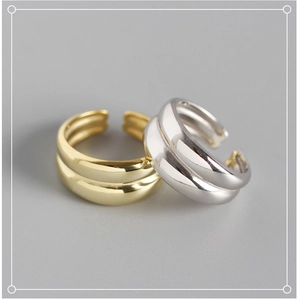 Close-up of minimalist double-layer open rings in polished gold and silver finishes