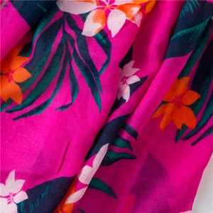 Detailed macro view of tropical floral print fabric with pink and orange patterns
